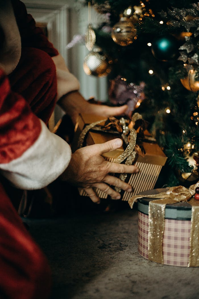 Santa Claus placing gifts under a beautifully decorated Christmas tree, capturing the holiday spirit.
