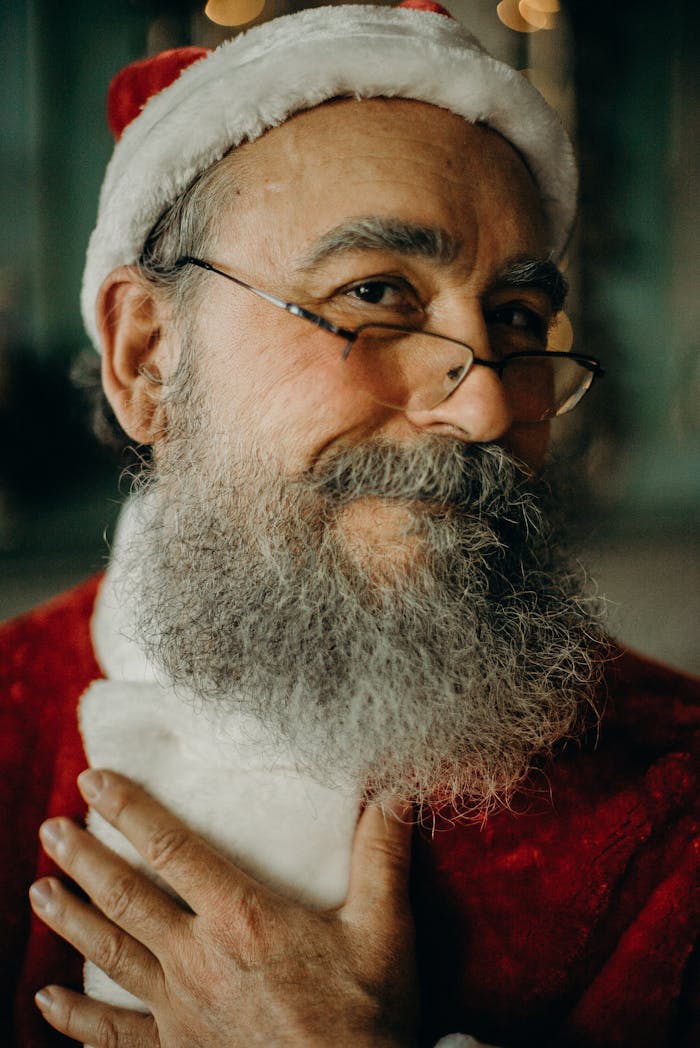 Close-up portrait of a smiling Santa Claus in traditional costume, embodying holiday spirit.